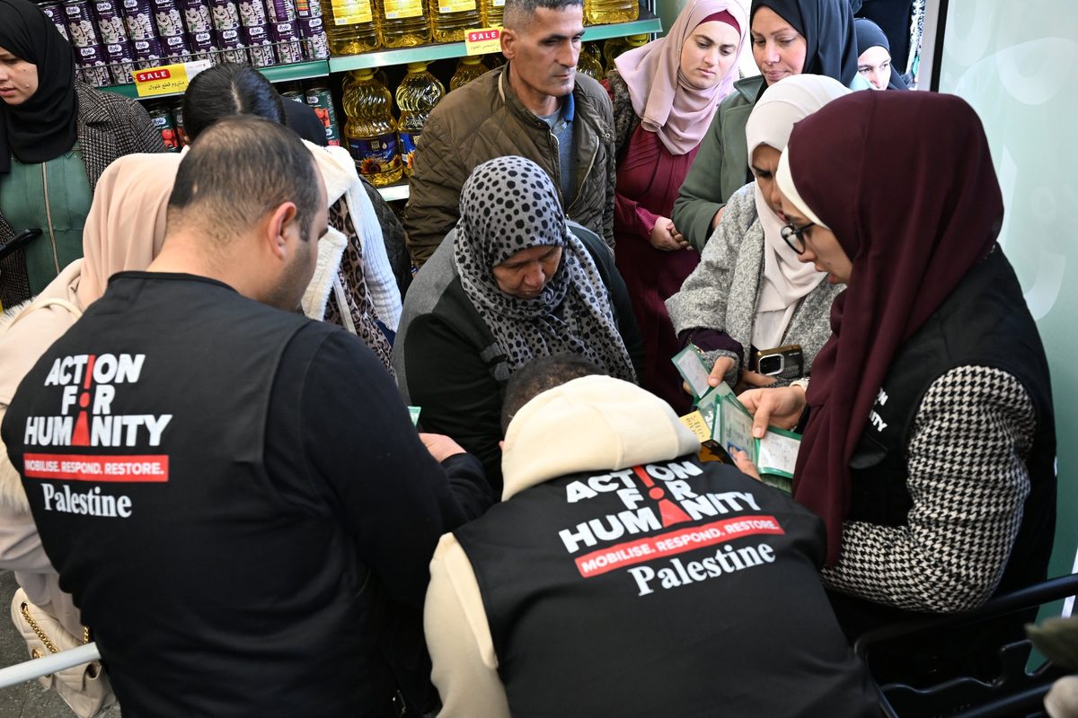 Aid workers handing out vouchers to a crowd