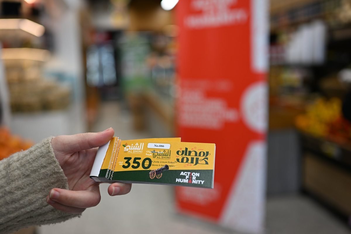 A hand holds a 350 shekel food voucher