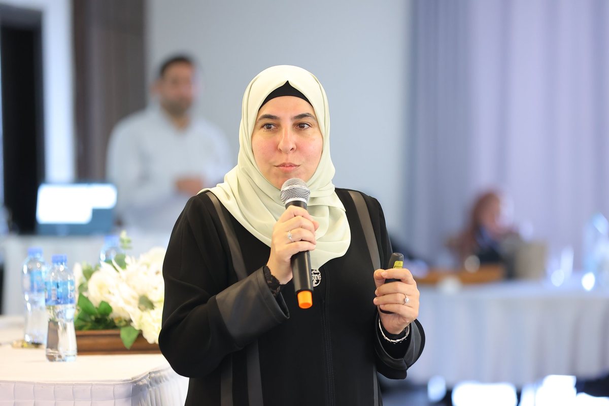 A woman speaks into a microphone at a workshop
