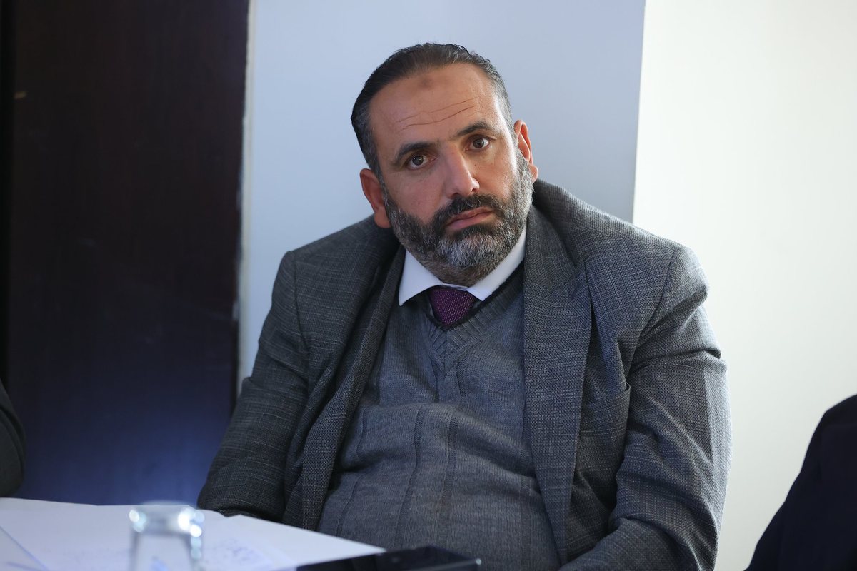 A participant in a suit listening