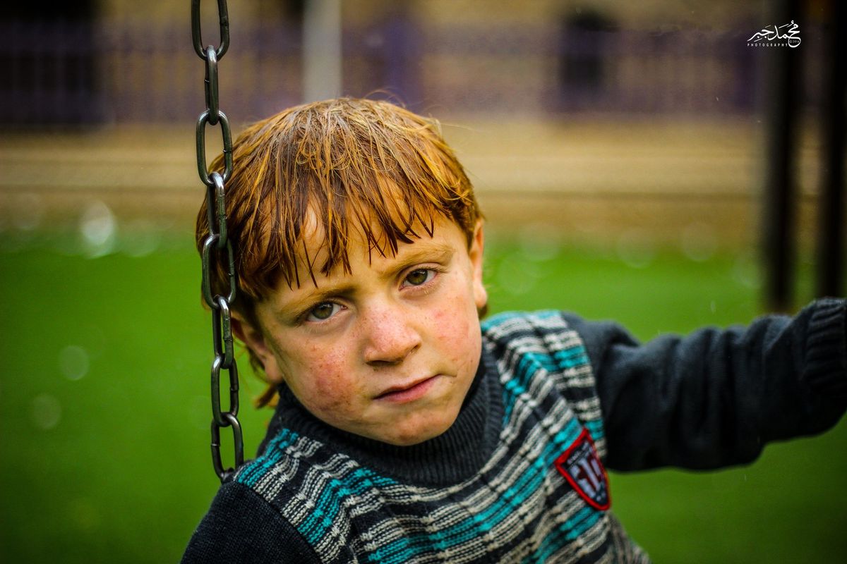 A red-haired boy on a swing