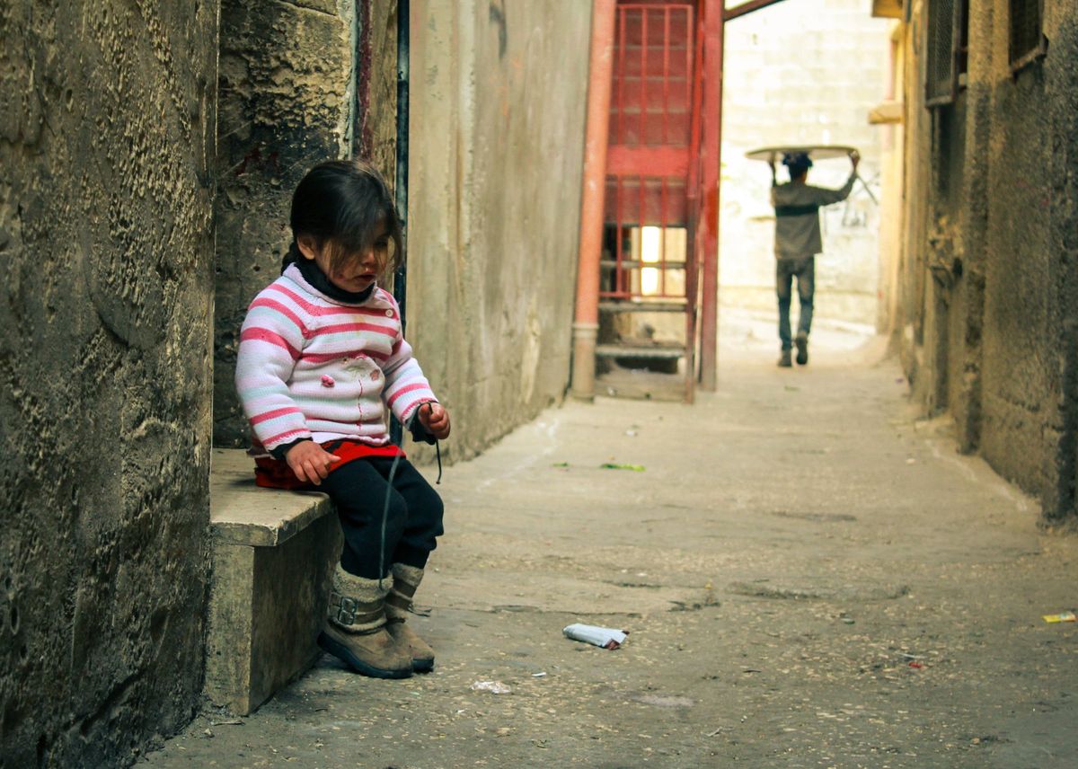 A girl sitting in a narrow alley
