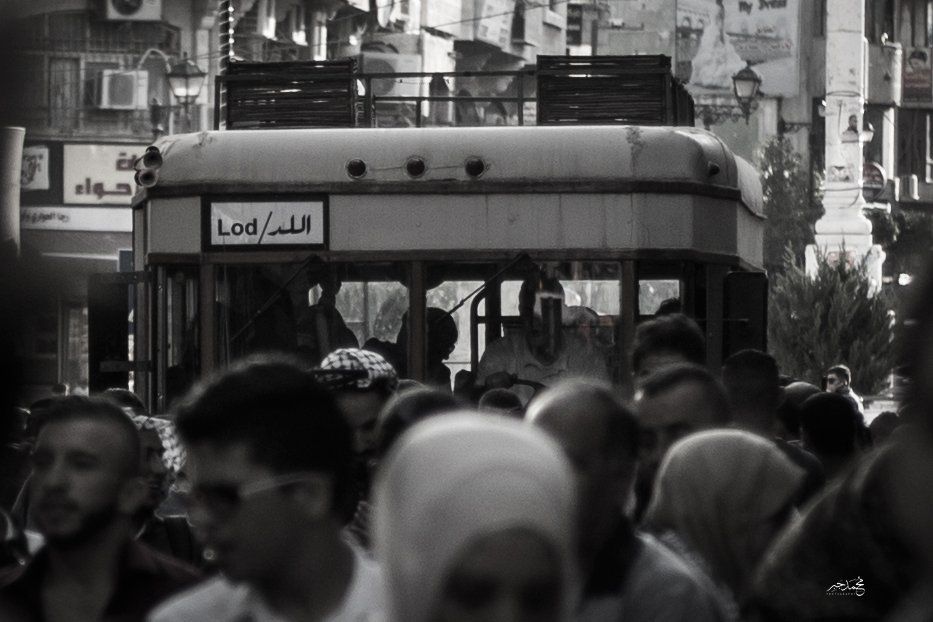 A crowd around an old bus, black and white