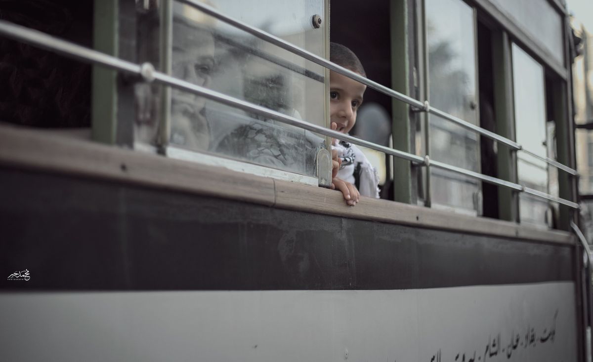 A child looking out of a bus window