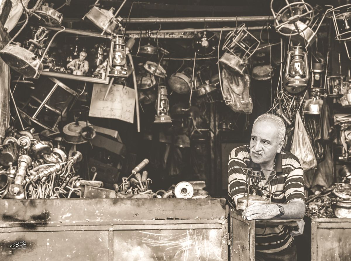 A shopkeeper among old brass lamps