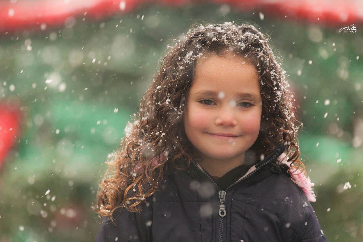 The curly-haired girl smiling in the snow