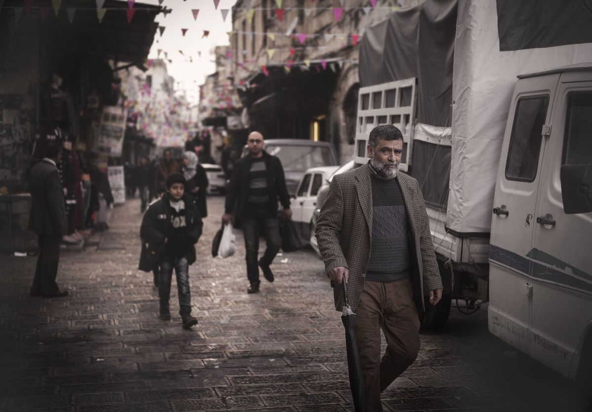 A man walking through a busy market street