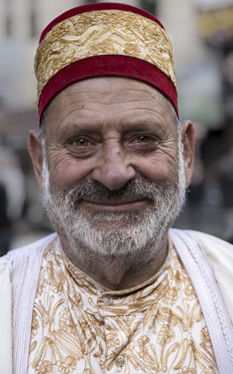 A smiling man in a red tarboosh