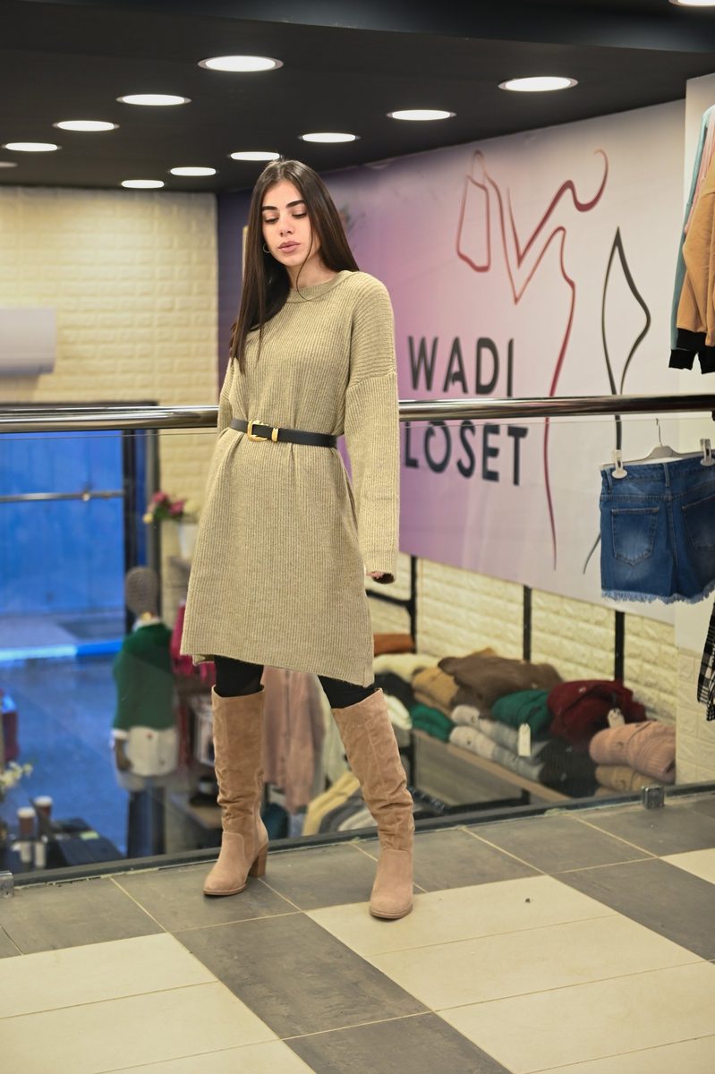 A beige knit dress and boots inside the store