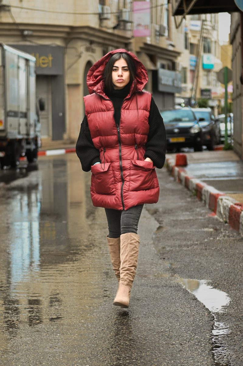 A red puffer vest on a wet street
