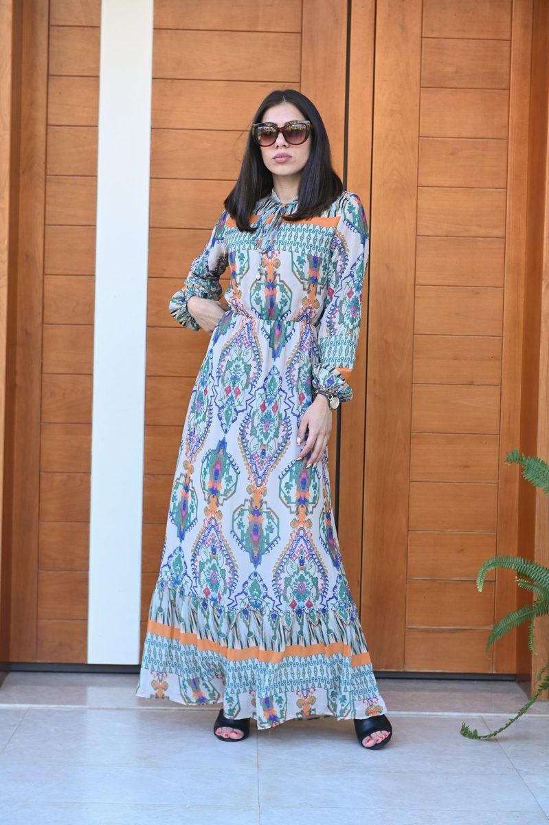 A blue patterned maxi dress at a wooden door