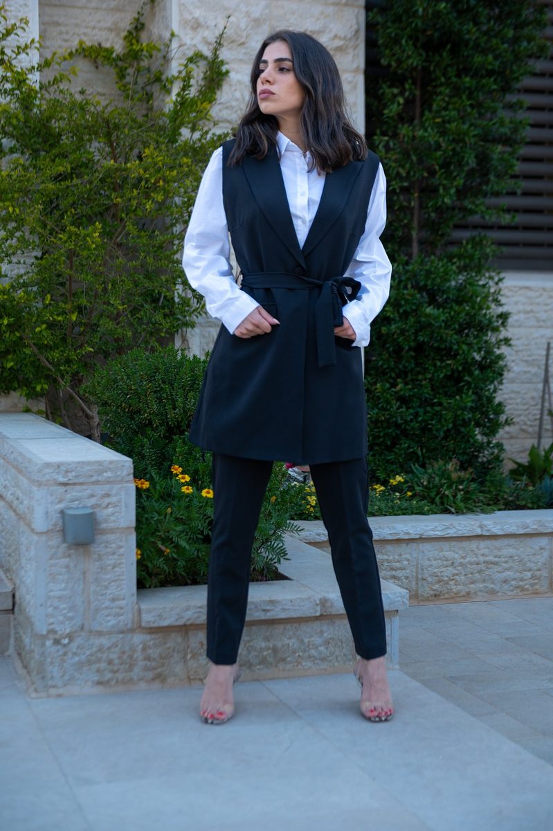 A black vest and trousers in a garden