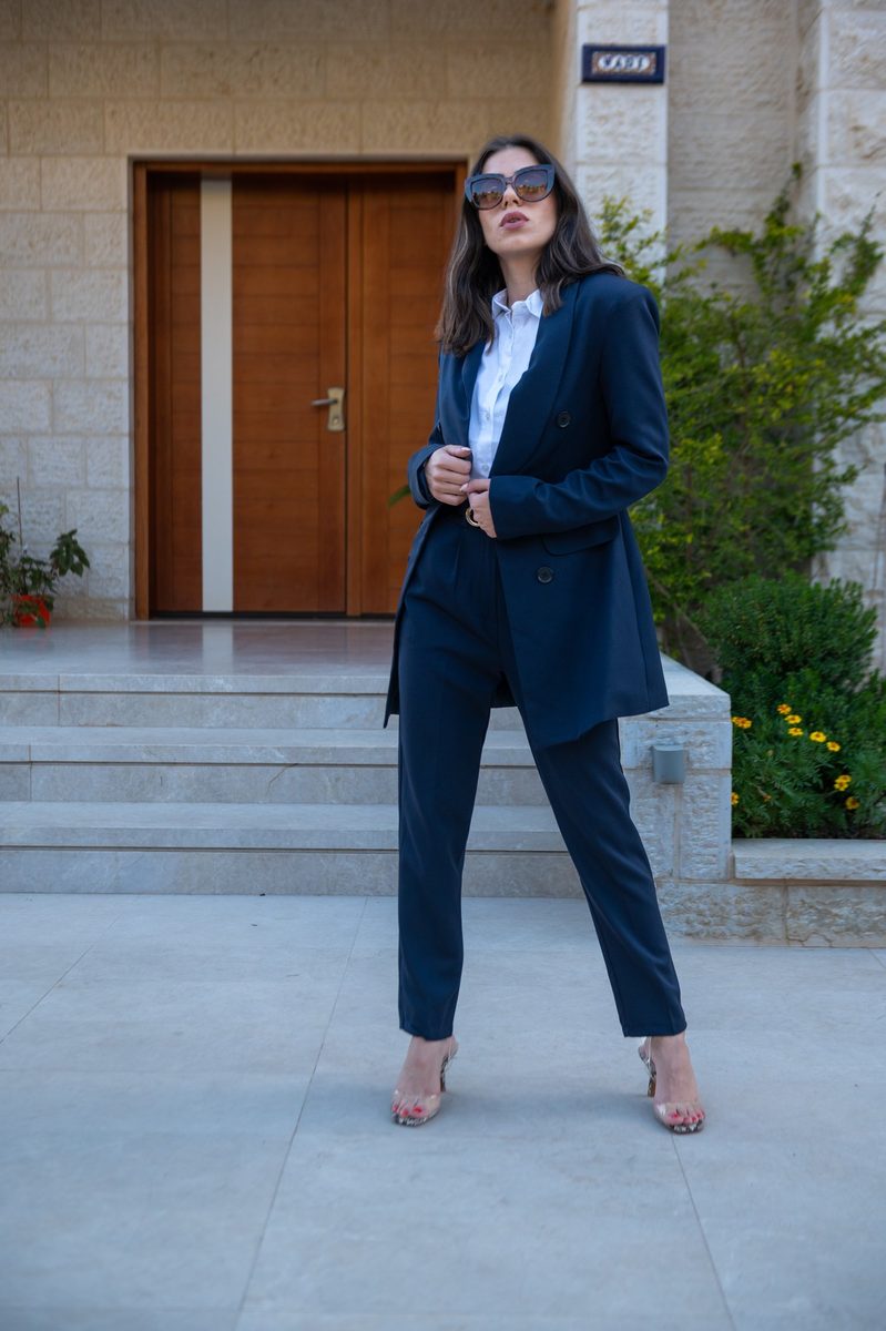 A navy blazer and trousers on stone steps