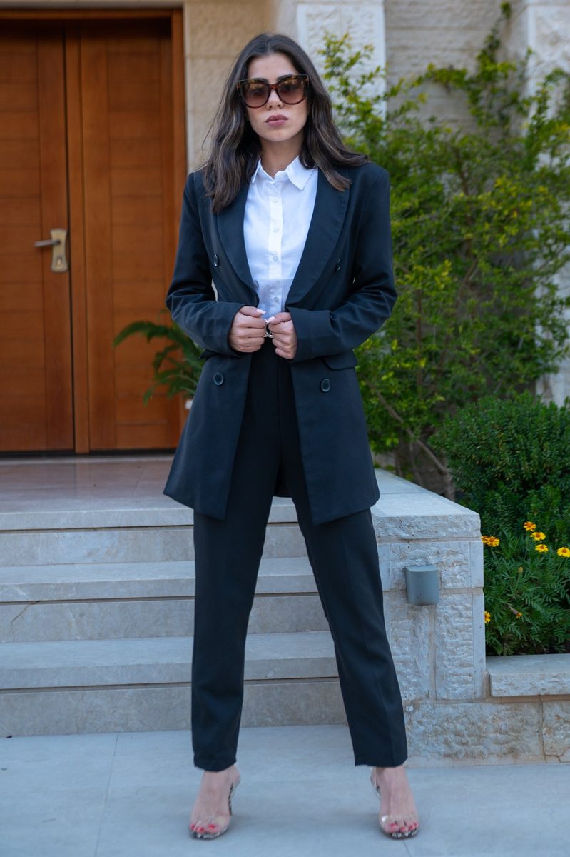 A black blazer and sunglasses in a garden