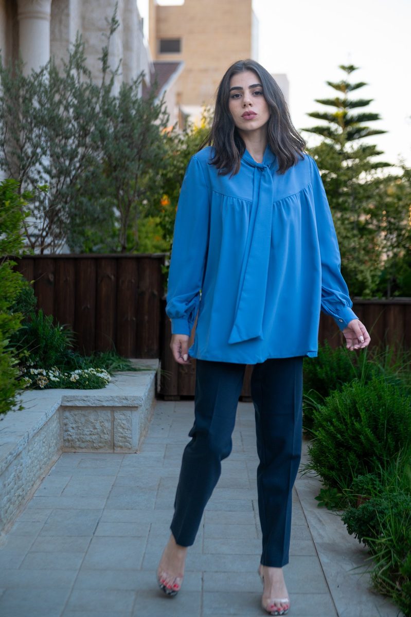 A blue blouse and jeans in a garden