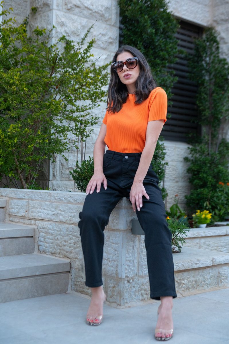 An orange top, sitting on a stone wall