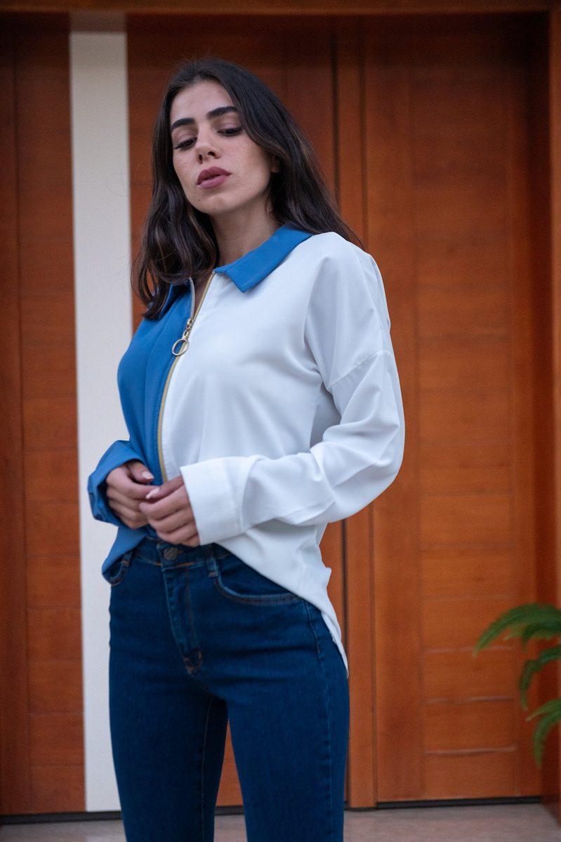A white-and-blue shirt and jeans at a wooden door